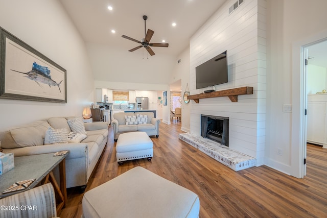 living area featuring recessed lighting, wood finished floors, ceiling fan, a fireplace, and high vaulted ceiling