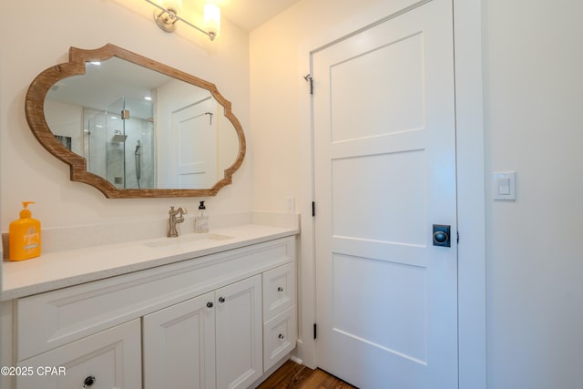 bathroom with a shower stall, vanity, and wood finished floors
