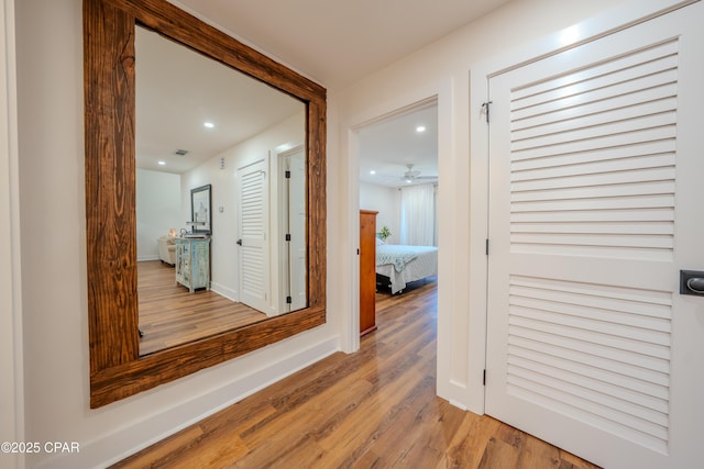 hallway with recessed lighting, wood finished floors, and baseboards