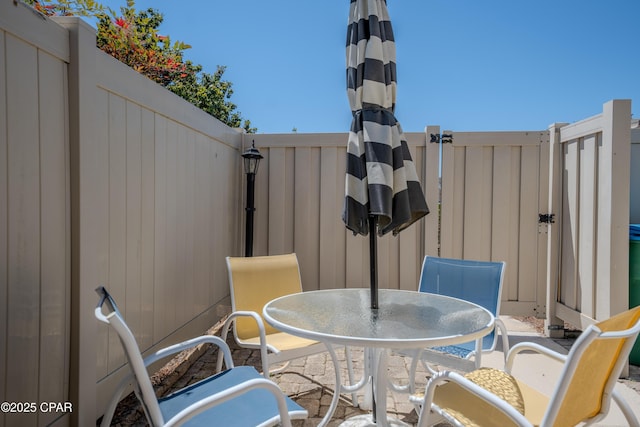 view of patio featuring outdoor dining area and fence