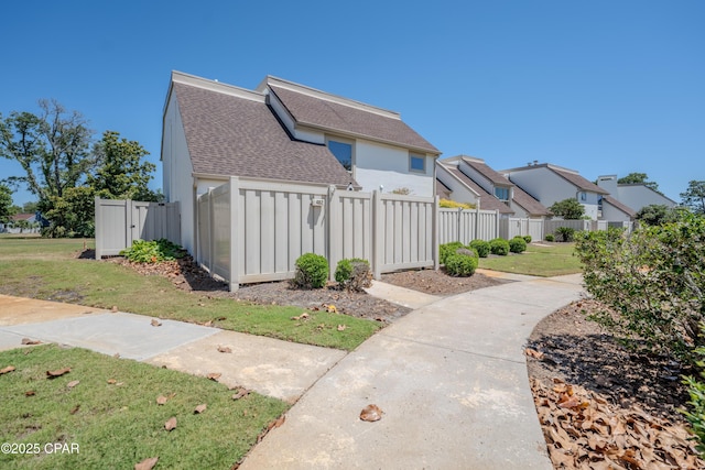 view of side of home with a shingled roof and a residential view