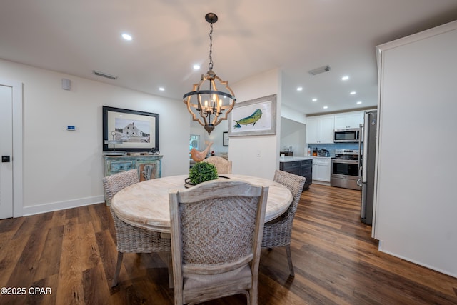 dining space featuring a chandelier, recessed lighting, dark wood finished floors, and baseboards
