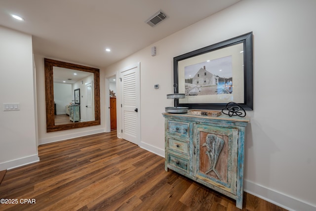 hallway with wood finished floors, baseboards, and recessed lighting
