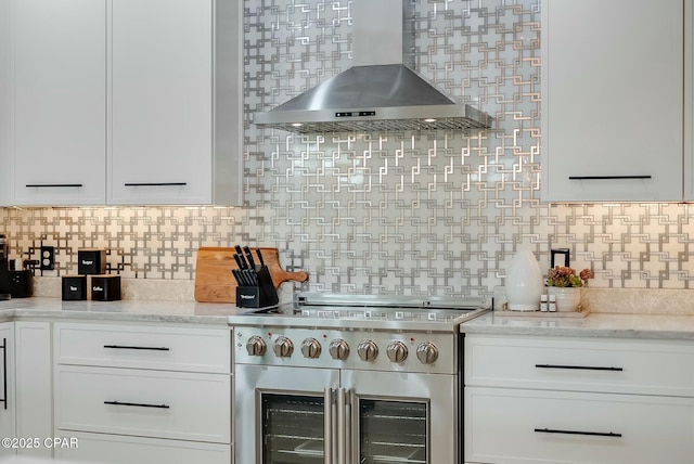 208 George C Wallace, Panama City Beach, FL 32413 - kitchen with high end range, exhaust hood, white cabinets, decorative backsplash, and light stone countertops