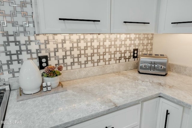 208 George C Wallace, Panama City Beach, FL 32413 - kitchen with white cabinets, tasteful backsplash, and light stone countertops