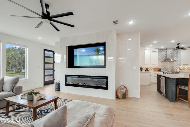 208 George C Wallace, Panama City Beach, FL 32413 - living area featuring ceiling fan, light wood-style flooring, a glass covered fireplace, and recessed lighting