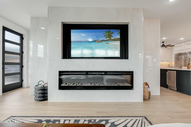 208 George C Wallace, Panama City Beach, FL 32413 - detailed view of stainless steel built in fridge, wood finished floors, a glass covered fireplace, dishwashing machine, and recessed lighting