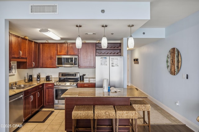 9860 S Thomas Dr Unit 1824, Panama City Beach, FL 32408 - kitchen featuring stainless steel appliances, a kitchen breakfast bar, light stone counters, decorative light fixtures, and a center island
