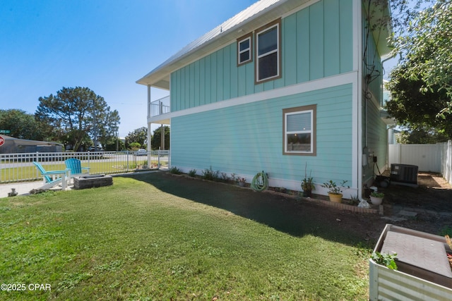111 George C Wallace Blvd, Panama City Beach, FL 32413 - view of side of property with board and batten siding, an outdoor fire pit, central air condition unit, and a balcony
