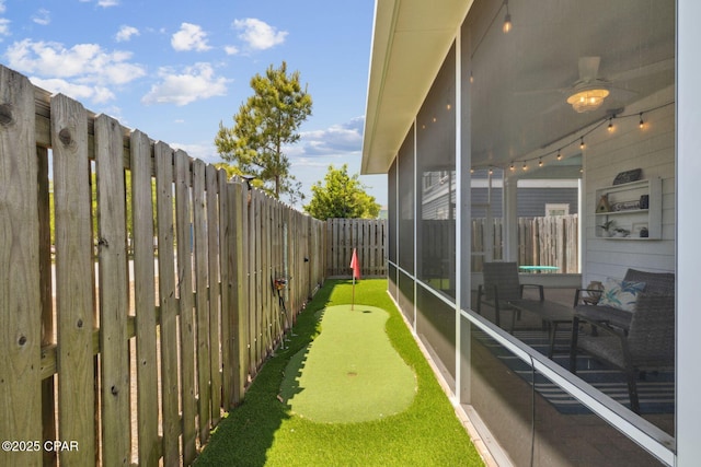 13 St. Vincent Lane, Inlet Beach, FL 32461 - fenced backyard featuring an area to practice putting, a sunroom, and a ceiling fan