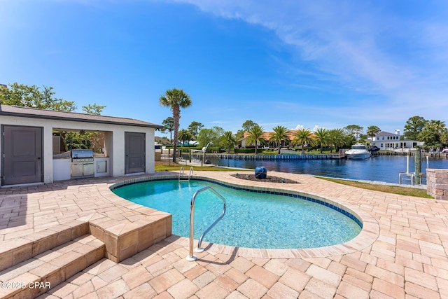 swimming pool featuring area for grilling, a patio area, a water view, and a grill