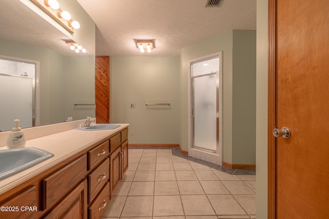 2324 Raintree Pl, Lynn Haven, FL 32444 - full bathroom featuring a stall shower, baseboards, double vanity, tile patterned flooring, and a textured ceiling