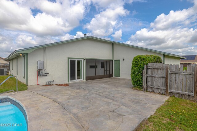 2324 Raintree Pl, Lynn Haven, FL 32444 - rear view of house featuring stucco siding, a patio, fence, central AC, and an outdoor pool