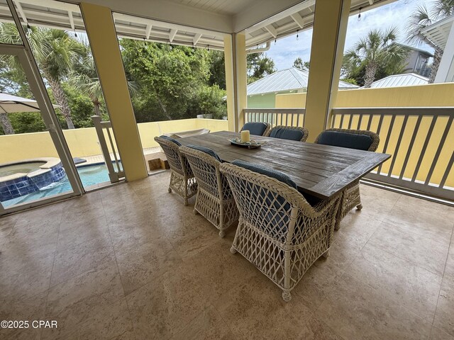 sunroom featuring a jacuzzi and outdoor dining area