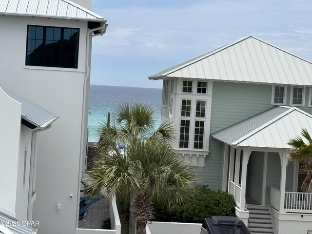 view of side of home featuring a water view, a standing seam roof, and metal roof