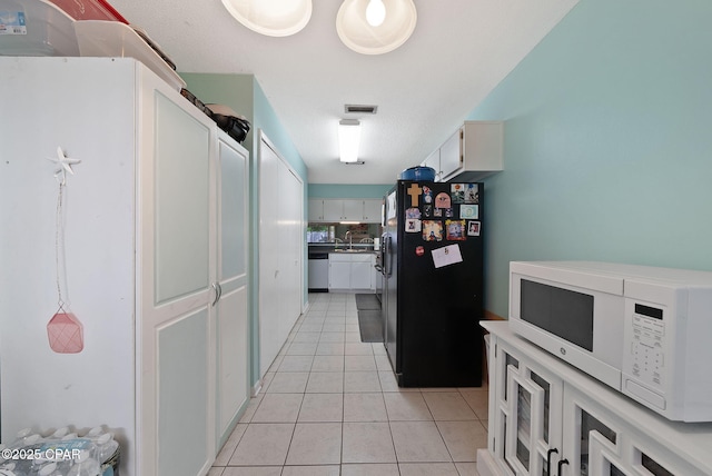 hall featuring light tile patterned floors and a sink