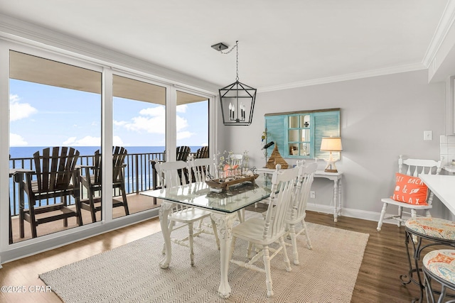 6905 Thomas Dr Unit 807, Panama City Beach, FL 32408 - dining room featuring crown molding, wood finished floors, baseboards, a chandelier, and a water view
