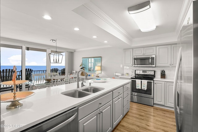 6905 Thomas Dr Unit 807, Panama City Beach, FL 32408 - kitchen with appliances with stainless steel finishes, a sink, decorative backsplash, light countertops, and crown molding