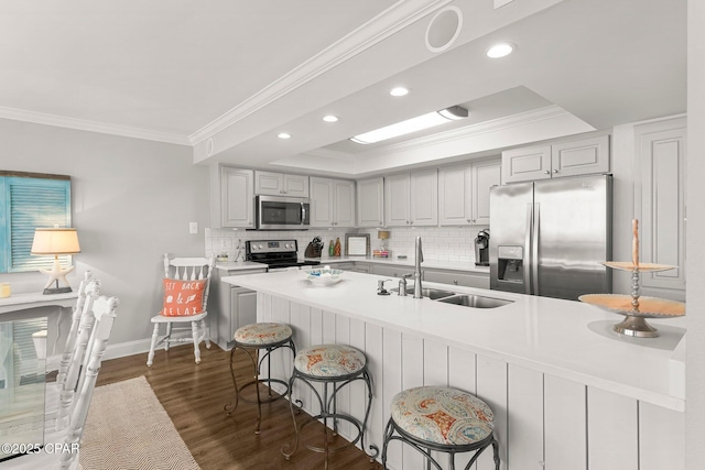 6905 Thomas Dr Unit 807, Panama City Beach, FL 32408 - kitchen with appliances with stainless steel finishes, crown molding, a sink, dark wood finished floors, and backsplash