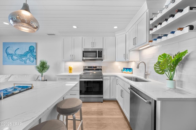 17735 Front Beach Rd Unit 4, Panama City Beach, FL 32413 - kitchen with appliances with stainless steel finishes, a sink, recessed lighting, light stone countertops, and white cabinetry