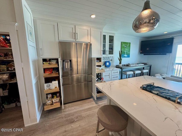17735 Front Beach Rd Unit 4, Panama City Beach, FL 32413 - kitchen featuring stainless steel fridge, white cabinets, light stone counters, and light wood-style flooring