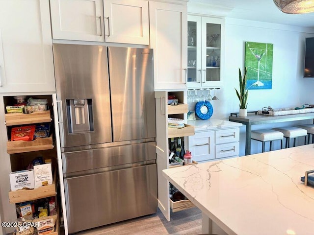 17735 Front Beach Rd Unit 4, Panama City Beach, FL 32413 - kitchen featuring stainless steel refrigerator with ice dispenser, white cabinetry, glass insert cabinets, and light wood-style floors