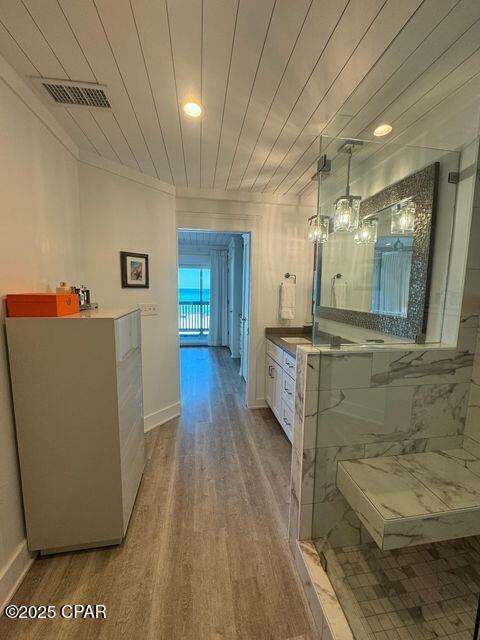17735 Front Beach Rd Unit 4, Panama City Beach, FL 32413 - full bath with vanity, wood finished floors, a marble finish shower, ornamental molding, and a chandelier