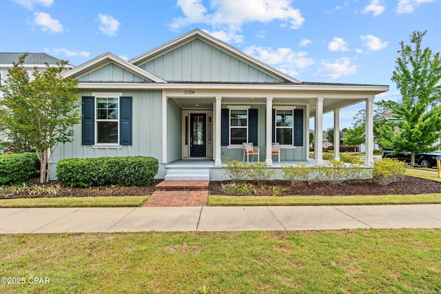 3104 Heartleaf E Ave, Panama City, FL 32405 - view of front facade with board and batten siding, a porch, and a front lawn
