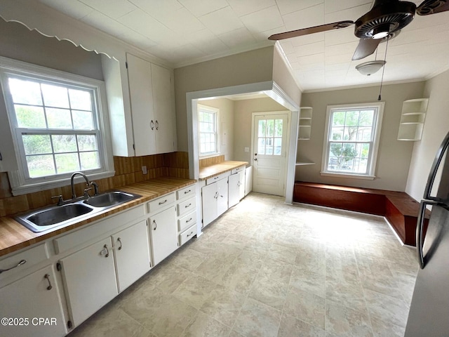 4276 2nd Ave, Marianna, FL 32446 - kitchen with a sink, crown molding, white cabinets, ceiling fan, and tasteful backsplash