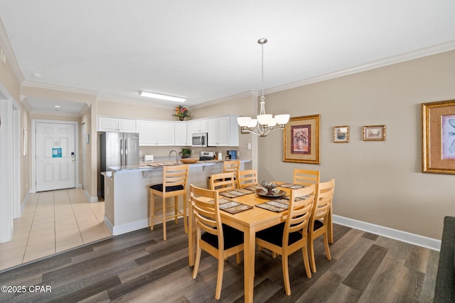 17545 Front Beach Rd Unit 1705, Panama City Beach, FL 32413 - dining room with a chandelier, light wood finished floors, ornamental molding, and baseboards