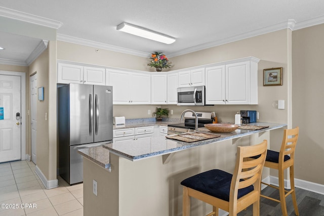 17545 Front Beach Rd Unit 1705, Panama City Beach, FL 32413 - kitchen featuring appliances with stainless steel finishes, light stone countertops, a peninsula, baseboards, and crown molding