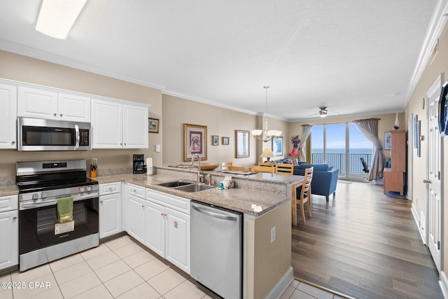 17545 Front Beach Rd Unit 1705, Panama City Beach, FL 32413 - kitchen with stainless steel appliances, a sink, a peninsula, ornamental molding, and ceiling fan