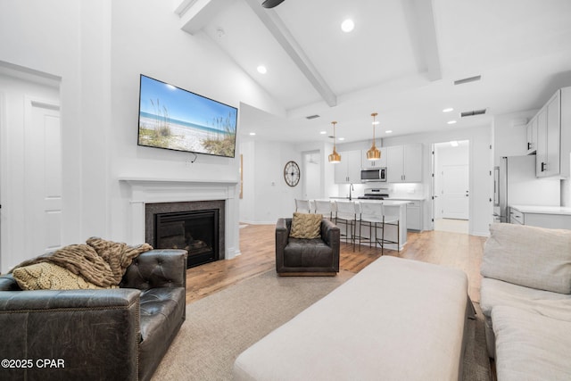 8676 Coral Reef Way, Panama City Beach, FL 32413 - living room featuring recessed lighting, a glass covered fireplace, light wood-type flooring, and baseboards