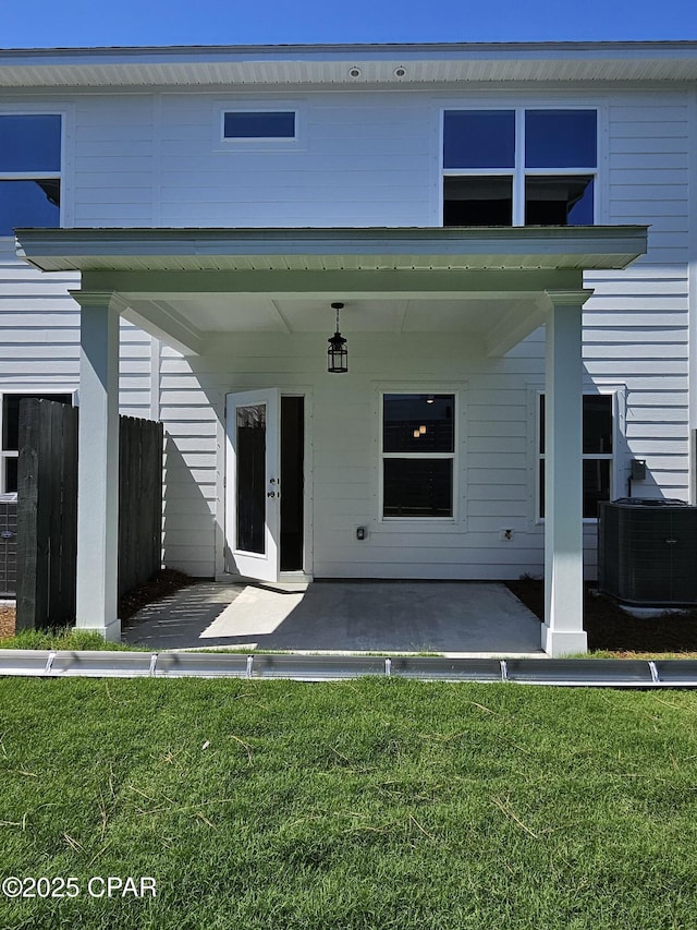 237 Skylah Ln Unit 19, Panama City Beach, FL 32407 - rear view of house with central AC unit, a patio area, and a lawn