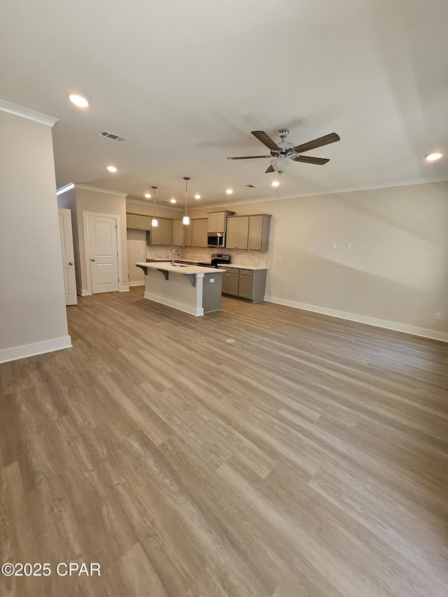 237 Skylah Ln Unit 19, Panama City Beach, FL 32407 - unfurnished living room with crown molding, recessed lighting, baseboards, ceiling fan, and light wood-style floors