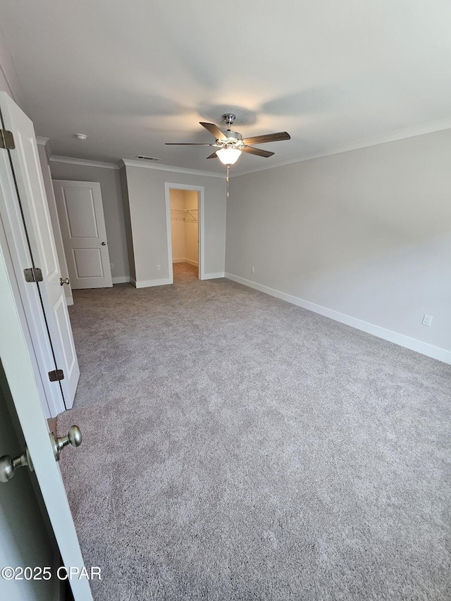 237 Skylah Ln Unit 19, Panama City Beach, FL 32407 - unfurnished bedroom with carpet, crown molding, baseboards, a spacious closet, and ceiling fan