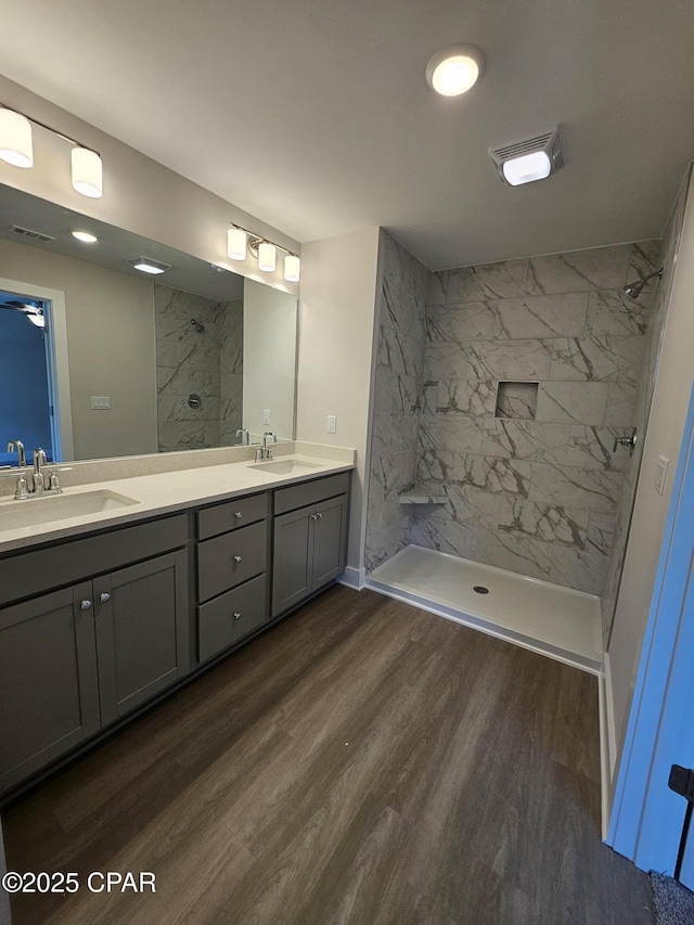 237 Skylah Ln Unit 19, Panama City Beach, FL 32407 - bathroom with wood finished floors, a marble finish shower, double vanity, and baseboards