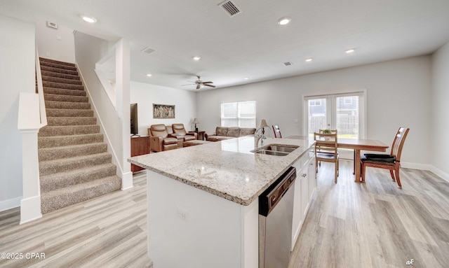4862 Sweetspire Dr, Panama City, FL 32404 - kitchen featuring dishwasher, light wood-type flooring, white cabinetry, light stone counters, and a kitchen island with sink