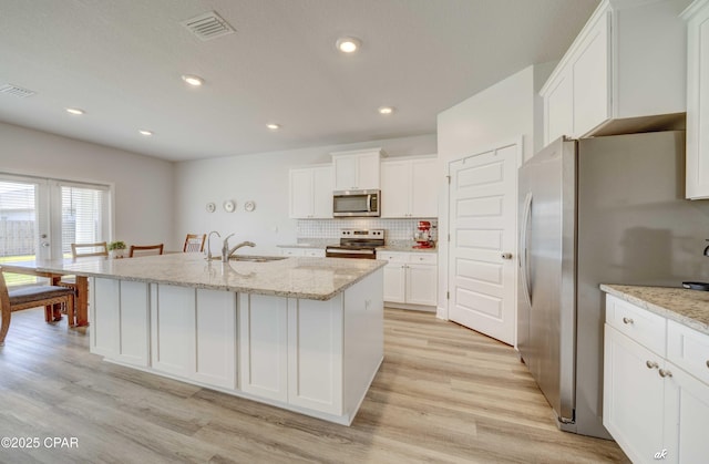 4862 Sweetspire Dr, Panama City, FL 32404 - kitchen featuring appliances with stainless steel finishes, white cabinets, light wood finished floors, light stone countertops, and recessed lighting