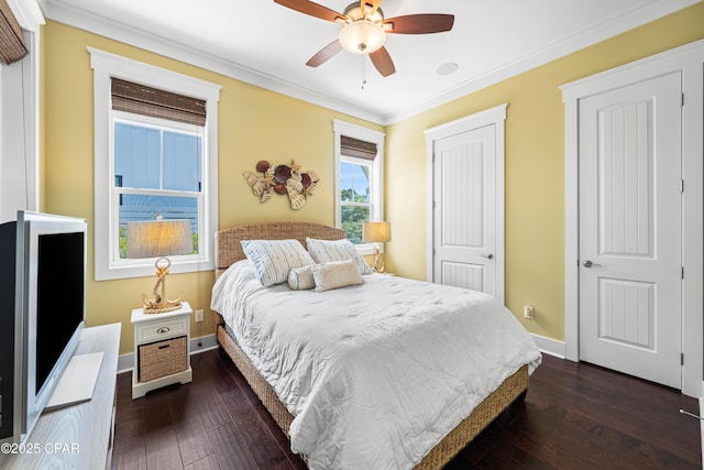 bedroom featuring dark wood finished floors, ornamental molding, baseboards, a closet, and ceiling fan