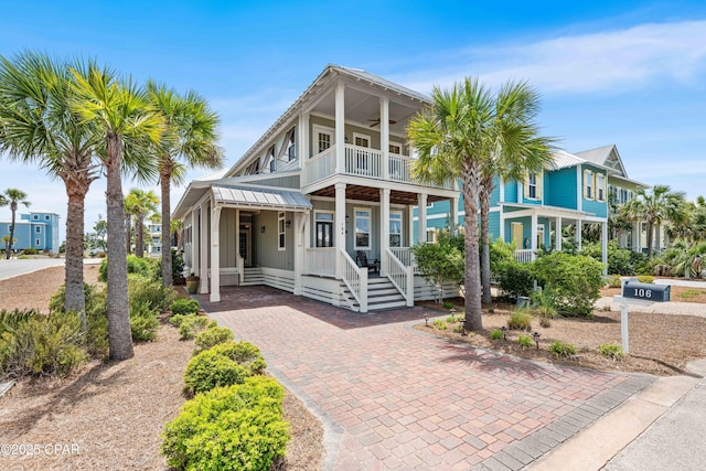 view of front of house featuring a balcony, a ceiling fan, and a porch