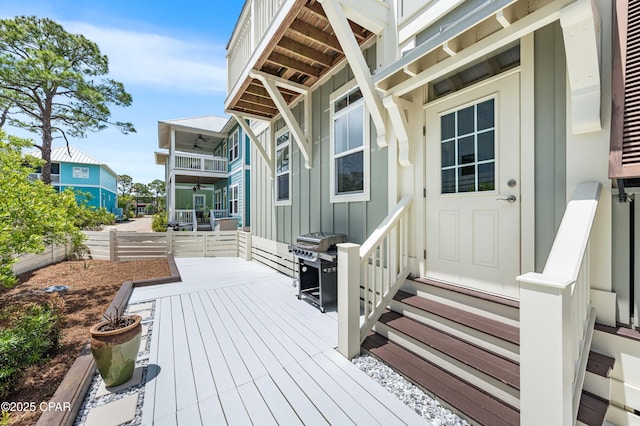 wooden terrace with grilling area, fence, and entry steps