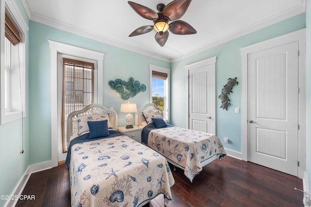bedroom with dark wood-style flooring, crown molding, baseboards, ceiling fan, and a closet