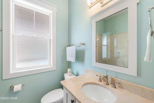 bathroom with a tile shower, toilet, and vanity