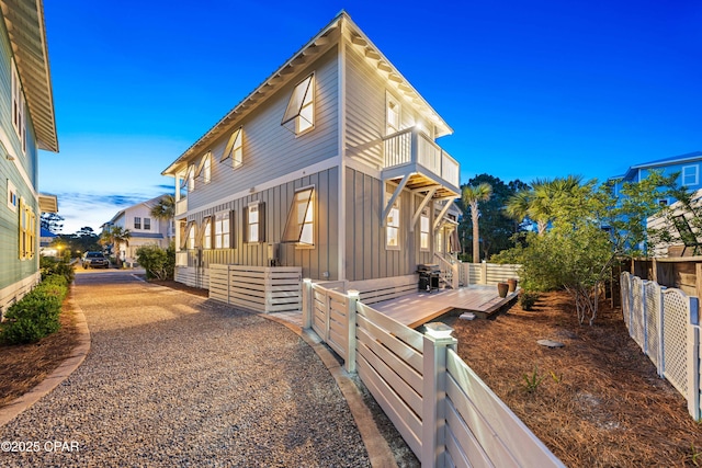 view of home's exterior featuring board and batten siding, a balcony, and a fenced backyard