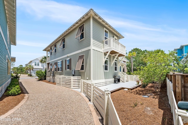 view of property exterior with a balcony and fence