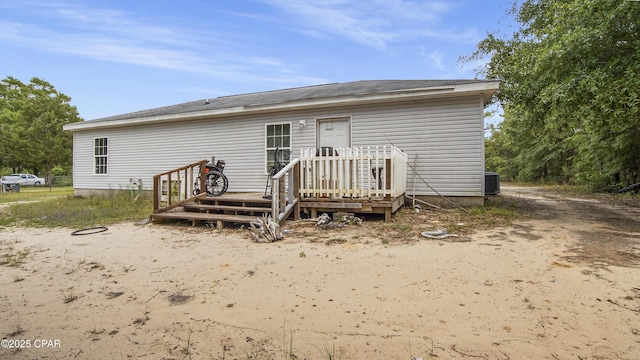 rear view of house with a wooden deck and cooling unit