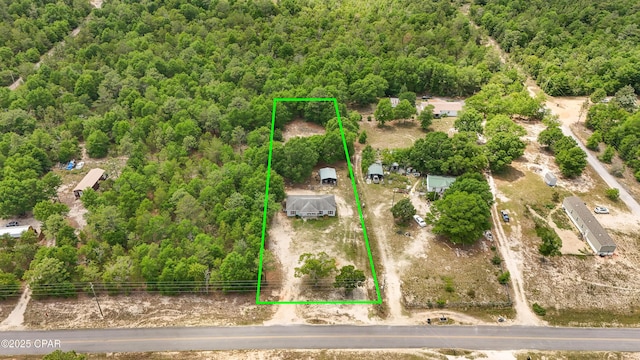 aerial overview of property's location with a heavily wooded area and property boundaries highlighted