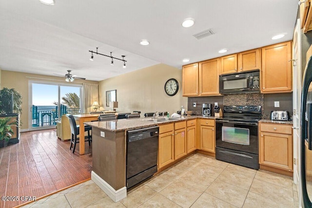 16701 Front Beach Rd Unit 306, Panama City Beach, FL 32413 - kitchen with black appliances, a peninsula, a sink, light stone countertops, and decorative backsplash