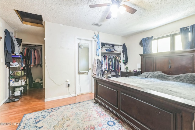 2322 Silversides Loop, Pensacola, FL 32526 - bedroom with light wood-style floors, a textured ceiling, baseboards, a closet, and a ceiling fan